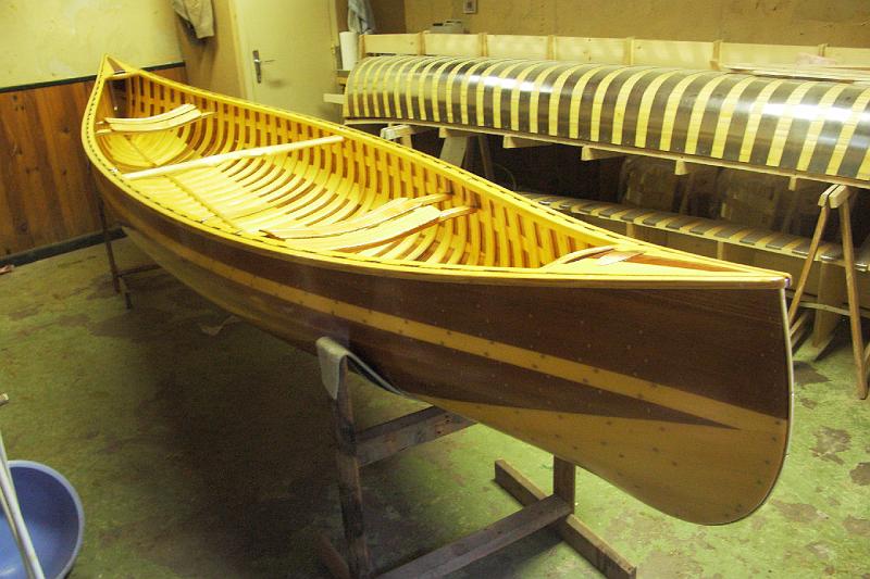 PICT2210.JPG - Le premier Migrateur 4.50 construit à La Canoterie (en 2006) l'a été sur un moule traditionnel américain (démonté en arrière plan) avec bandes métalliques pour l'auto-rivetage des bordés larges sur les membrures ployées à la vapeur. Ce procédé est habituellement réservé aux entoilés (wood-canvas canoes), hélas mal connus en France.